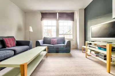 a living room with a couch and a flat screen tv at JOIVY Bright 1 bed flat, close to Princess Street in Edinburgh