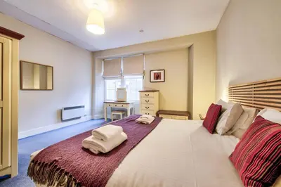 a bedroom with a large bed with towels on it at JOIVY Stylish Home in New Town in Edinburgh