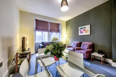 a living room with a table and chairs at JOIVY Stylish Home in New Town in Edinburgh