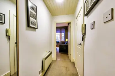 a corridor of a hallway with white walls and a door at JOIVY Charming Apt close to City Centre in Edinburgh