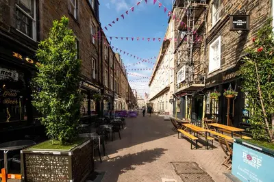 an empty street with tables and benches in a city at JOIVY Charming Apt close to City Centre in Edinburgh