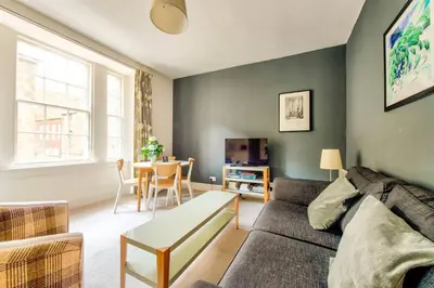 a living room with a couch and a table at JOIVY Amazing Location! Lovely Rose St Apt in New Town in Edinburgh