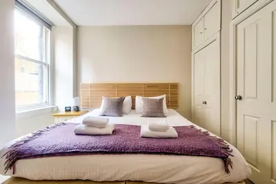 a bedroom with a large bed with two pillows at JOIVY Amazing Location! Lovely Rose St Apt in New Town in Edinburgh