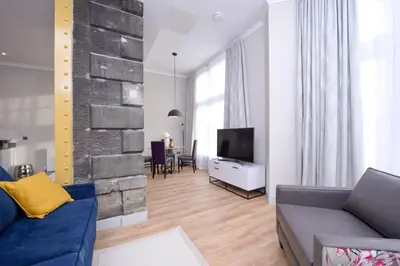 a living room with a couch and a tv at Destiny Scotland Charlotte Square Apartments in Edinburgh