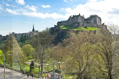 a castle on top of a hill with trees at Destiny Scotland Charlotte Square Apartments in Edinburgh