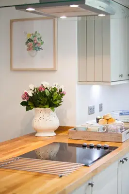 a vase with flowers on a counter in a kitchen at The Gardener's Cottage in Dunblane