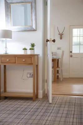 a room with a desk and a mirror and a table at The Gardener's Cottage in Dunblane