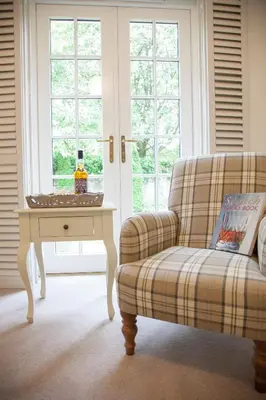 a living room with a couch and a table and window at The Gardener's Cottage in Dunblane