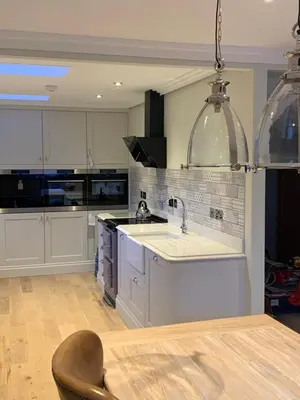 a kitchen with white cabinets and a sink and a chair at Stormfront Luxury Hideaway Glencoe Ballachulish Highlands Near Fortwilliam in Glencoe
