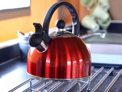 a red tea kettle is sitting on the stove at Carr's Hill Luxury Safari Tents in Denny