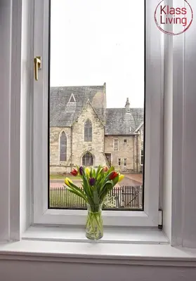a vase of flowers sitting on a window sill at Whifflet Apartment by Klass Living Coatbridge in Coatbridge