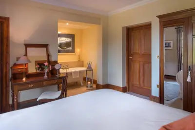 a bedroom with a bed and a sink and a tub at Glencoe House in Glencoe