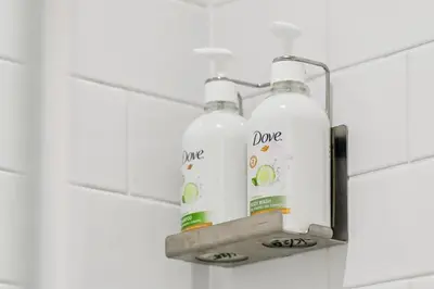 two bottles of cleaning products on a shelf in a bathroom at Garner Hotel Edinburgh - Haymarket by IHG in Edinburgh
