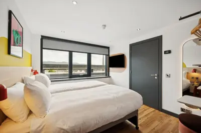 a bedroom with a large bed and a window at Garner Hotel Edinburgh - Haymarket by IHG in Edinburgh