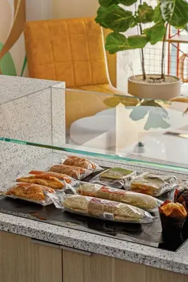 a display case with a bunch of hot dogs and pastries at Garner Hotel Edinburgh - Haymarket by IHG in Edinburgh