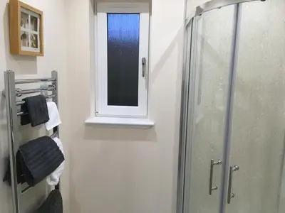 a bathroom with a shower and a window at 1 Balnakeil, Kirk Road in Oban