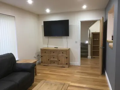 a living room with a couch and a flat screen tv at 1 Balnakeil, Kirk Road in Oban