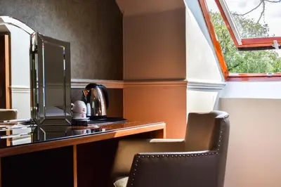 a desk with a mirror and a chair in a room at Dalziel Park Hotel in Motherwell