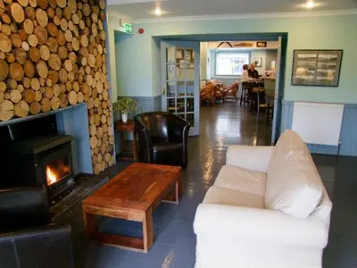 a living room with a fireplace and a white couch at The Colonsay Hotel in Isle of Colonsay