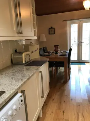 a kitchen with a table and a dining room at Kilchurn Suites in Loch Awe