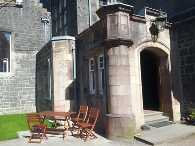 a table and chairs sitting next to a building at Kilchurn Suites in Loch Awe