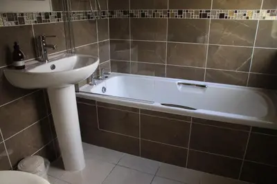 a bathroom with a sink and a bath tub and a sink at Kilchurn Suites in Loch Awe