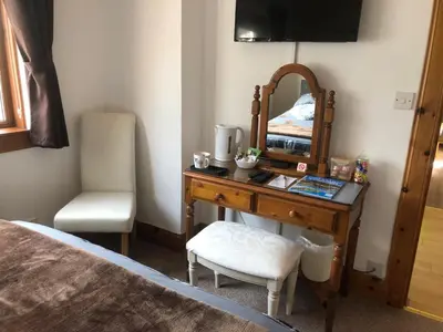 a bedroom with a desk with a mirror and a chair at The Woolly Rock in North Ballachulish