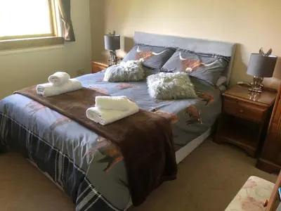 a bedroom with a bed with towels on it at The Woolly Rock in North Ballachulish