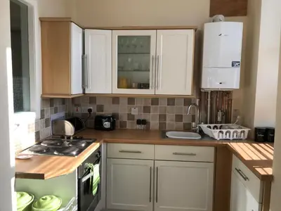 a kitchen with white cabinets and a counter top at Home with a view in Moffat