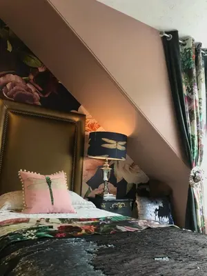 a bedroom with a bed with a pink pillow and a lamp at Altavona House in Oban