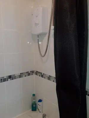 a bathroom with a shower curtain and a bath tub at Hardgate Gardens in Glasgow