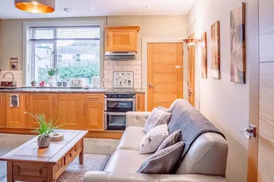 a living room with a couch and a table at Cottage Apartment in Dunblane