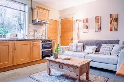 a living room with a couch and a table at Cottage Apartment in Dunblane