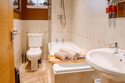 a bathroom with a toilet and a sink and a tub at Cottage Apartment in Dunblane