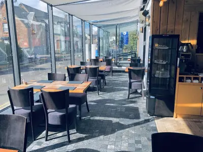 a restaurant with wooden tables and chairs and windows at The Drymen Inn in Drymen