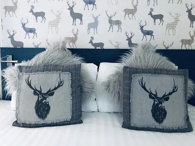 two pillows with a deer head on a bed at The Drymen Inn in Drymen