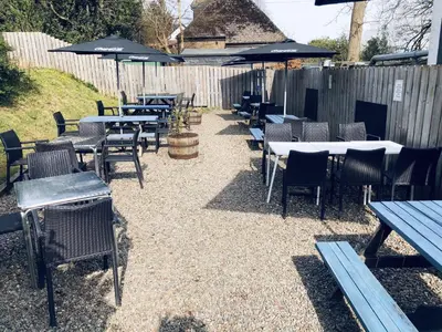 a group of tables and chairs with umbrellas at The Drymen Inn in Drymen