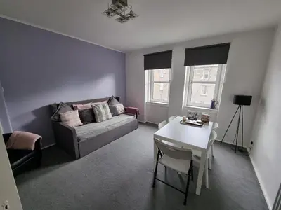 a living room with a couch and a table at Bespoke Tours Scotland Accommodation @ Morrison Street in Edinburgh