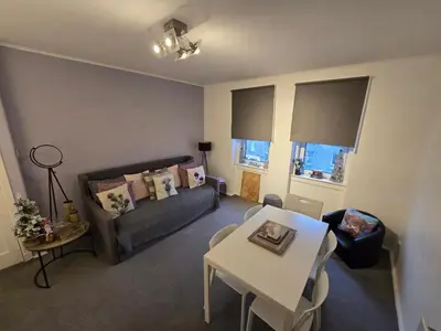 a living room with a couch and a table at Bespoke Tours Scotland Accommodation @ Morrison Street in Edinburgh