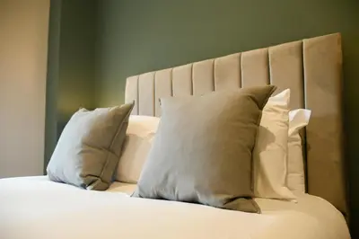 a white bed with white pillows on it at Raniven in Oban