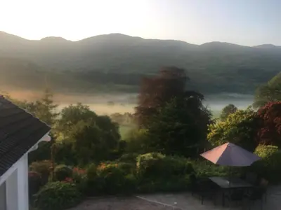 a view of a valley from a house with an umbrella at Invercreran Lodge Luxury Bed & Breakfast in Appin