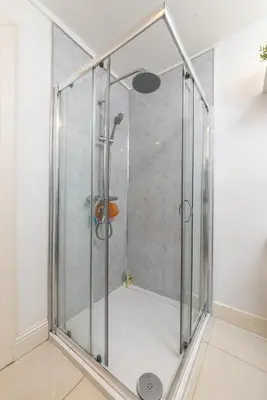 a shower with a glass door in a bathroom at Charming, Central & Spacious Georgian 3 bed APT in Edinburgh