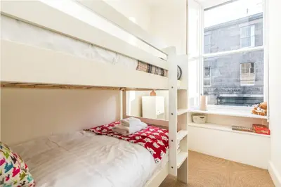 a bedroom with a bunk bed and a window at Charming, Central & Spacious Georgian 3 bed APT in Edinburgh