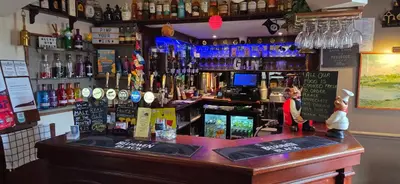a bar with a bar counter with bottles of alcohol at The Famous Star Hotel Moffat in Moffat