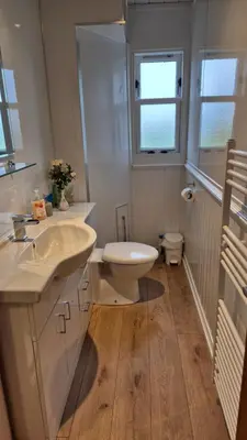 a bathroom with a sink and a toilet and a window at Hawthorn Self Catering Cottages in Benderloch