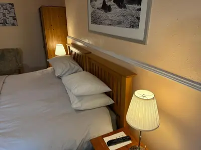 a bedroom with a bed with two pillows and a lamp at Glades House in Glasgow