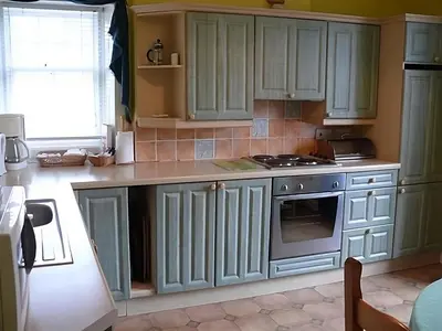 a kitchen with green cabinets and a stove at The Gardener's House in Covington