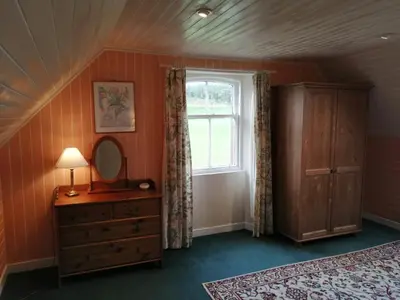 a bedroom with a window and a dresser and a mirror at The Gardener's House in Covington