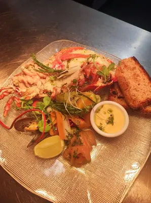 a plate of food with shrimp and vegetables on a table at The Gardener's House in Covington