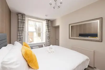a bedroom with a white bed and a window at JOIVY Splendid Flat near Edinburgh Castle in Edinburgh